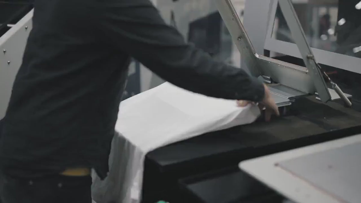 Heat press applying a DTF transfer to a garment in production